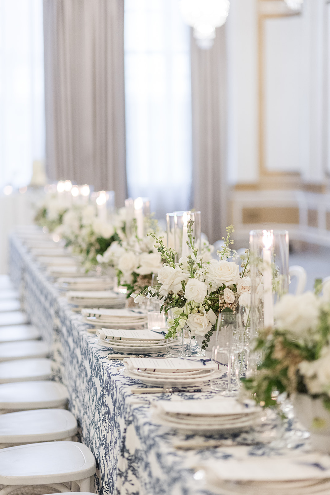 A beautiful wedding reception tablescape with white flowers and candles done up at The Benson Hotel Portland's Crystal Ballroom.